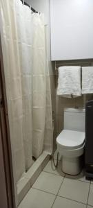 e bagno con servizi igienici e tenda per la doccia. di Eu & El Cozy Condo a Manila
