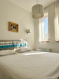 a bedroom with a large white bed with a window at Jaram Vile Apartmani in Kopaonik +44 photos