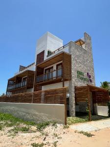 a building on the beach in front of the ocean at Casa Floratta - Flecheiras in Flecheiras