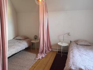 a bedroom with two beds with pink curtains at Stor lägenhet för familj eller företag in Norrköping