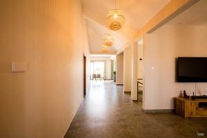 a hallway with a flat screen tv on a wall at Naturo Villa, Villa No 11 in Île Malno