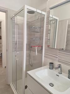 a white bathroom with a sink and a shower at Il Nido a due Passi da Assisi in Bastia Umbra +7 photos