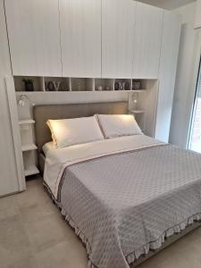 a bedroom with a large bed with white cabinets at Il Nido a due Passi da Assisi in Bastia Umbra