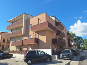 a building with cars parked in front of it at Il Nido a due Passi da Assisi in Bastia Umbra