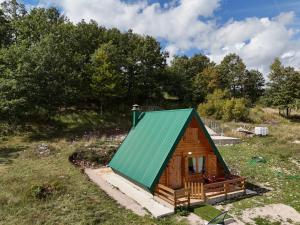 a small cabin with a green roof in a field at Forest rest in Plužine