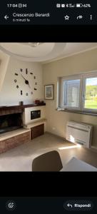 a living room with a clock on the wall at Home Imele in Villa San Sebastiano