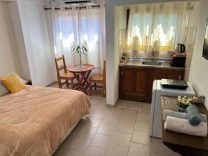 a bedroom with a bed and a table and a kitchen at Pequeño Monoambiente Céntrico IGR 1D in Puerto Iguazú +7 photos