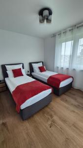 two beds in a room with white and red at Apartments Seibel Doppel-Zweibettzimmer mit Balkon in Reutlingen