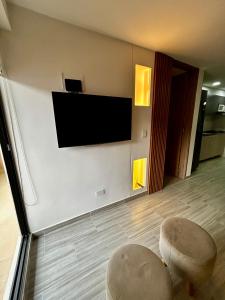 un soggiorno con 2 sgabelli e una TV a schermo piatto di Apto hito 6piso Armenia amoblado ad Armenia