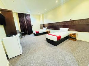 pokój hotelowy z dwoma łóżkami i telewizorem w obiekcie Rafahya Hotel 2 w Mekce