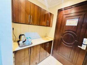 mała kuchnia z drewnianymi szafkami i zlewem w obiekcie Rafahya Hotel 2 w Mekce