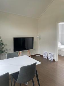 a room with a table and chairs and a flat screen tv at Honey Bear Pension in Pyeongchang