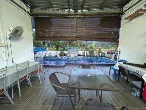 a patio with a table and chairs and a swimming pool at Nekmah Chalet in Yan