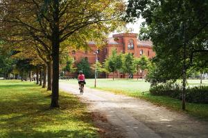 a person riding a bike down a path in front of a building at MINZ Studios in Bremen