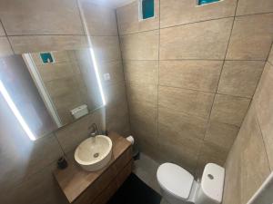 a bathroom with a toilet and a sink and a mirror at Casa lovits - Cozy One-Bedroom Apartment with Modern Comforts in Espinhal
