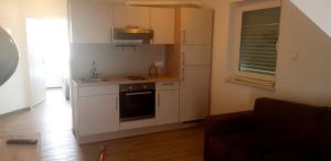 a kitchen with white cabinets and a stove top oven at A & M Apartments in Hildesheim