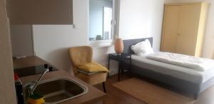 a small room with a bed and a sink at A & M Apartments in Hildesheim