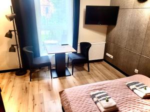 a room with a desk and a bed and a window at Apartament w sercu Elbląga in Elblag