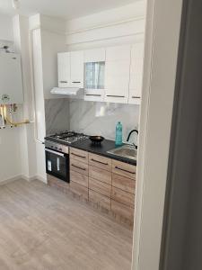 a kitchen with white cabinets and a stove top oven at Ana Maria in Lunca Cetăţuii