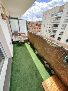 a small backyard with a lawn on a building at Grand T2 lumineux, 74 m in Villefranche-sur-Saône
