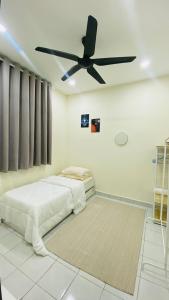 a bedroom with a bed and a ceiling fan at Prima Lodge Homestay in Kulim