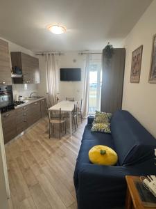 Una sala de estar con un sofá azul y una cocina. en Casa Giacomo stella maris, en Francavilla al Mare