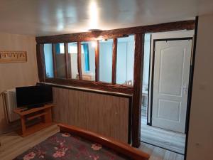 ein Zimmer mit Fenster, Tür und Fernseher in der Unterkunft FloMar in Léglantiers