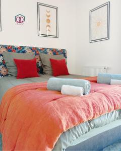 a large bed with red and blue pillows on it at Le cocon Familial - Appartement Kids friendly proche de la gare in Strasbourg +10 photos