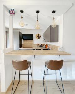 a kitchen with two bar stools and a counter top at Le cocon Familial - Appartement Kids friendly proche de la gare in Strasbourg