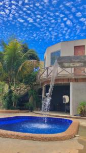a swimming pool with a fountain in front of a house at FamilySpace in Búzios