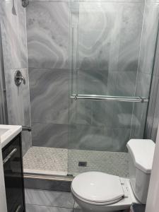 a bathroom with a shower with a toilet and a sink at Poolside Retreat with Private Patio in Brampton