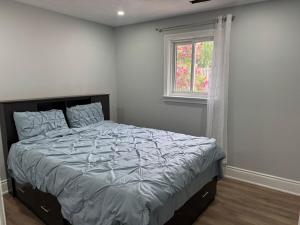 a bedroom with a bed and a window at Poolside Retreat with Private Patio in Brampton