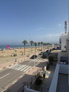 a view of a beach with palm trees and a parking lot at Martil appartement avec vue sur mer in Martil