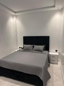 a bedroom with a large bed with a black headboard at Martil appartement avec vue sur mer in Martil