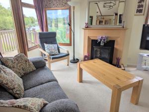 a living room with a couch and a table at Bend in the River Lodge in Stratford-upon-Avon