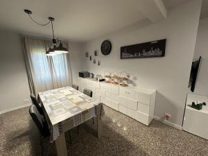 a dining room with a table and a clock on the wall at La casa di Amelie in Flero