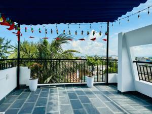 a balcony with flags and lights on a building at Nhan's Home in Hưng Nhơn (2)