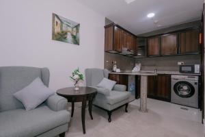 a living room with a couch and a table at Alraya Homes by Betu former Times Inn in Abu Dhabi