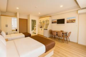a bedroom with a bed and a table and a kitchen at VALENCE HOTEL Taksim in Istanbul