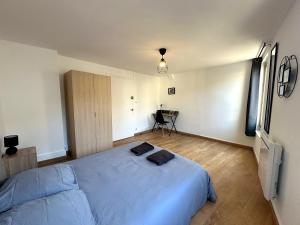 a bedroom with a large bed and a table at Les Hauteurs de Tonnerre - Centre Ville in Tonnerre
