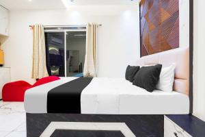 a bedroom with a black and white bed and a window at Hotel O SR & Guest House 2 in Sakardarā +22 photos