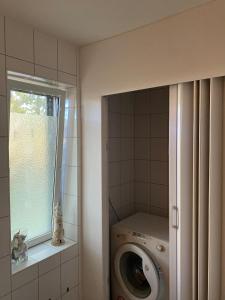 a washing machine in a bathroom with a window at Ferienhaus Seeruhe in Flessenow