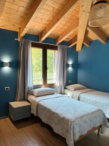 two beds in a room with blue walls at Room & Breakfast Olmo Tondo in San Giovanni in Persiceto +20 photos