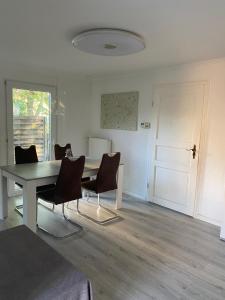 a dining room with a table and chairs and a door at Ferienhaus Seeruhe in Flessenow