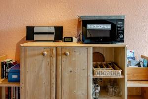 a microwave and a toaster oven on a wooden cabinet at Ferienwohnung Alpenpanorama in Oberau