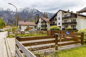 a house with a fence and mountains in the background at Ferienwohnung Alpenpanorama in Oberau