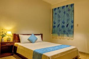 - une chambre avec un lit doté d'un rideau bleu et d'une fenêtre dans l'établissement Blue Ocean Resort, à Vung Tau