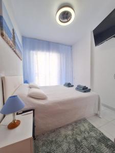 a bedroom with a large bed with a window at Solymar Torrevieja in Torrevieja