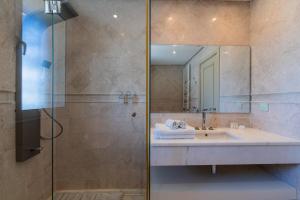 a bathroom with a sink and a shower with a mirror at Dar Elyssa in Sidi Bou Saïd +70 photos