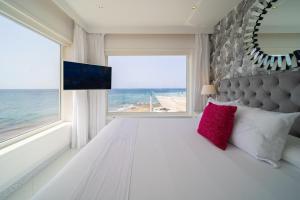 a bedroom with a bed with a large window at Lani's Suites de Luxe - Adults Only in Puerto del Carmen